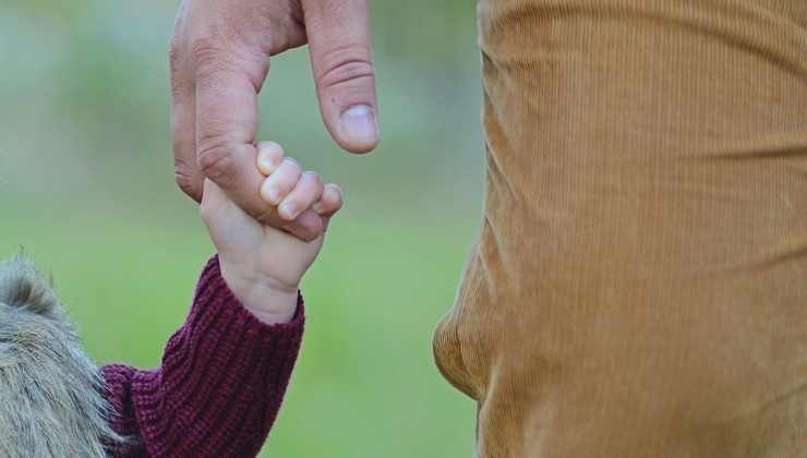 uomo e bambino mano nella mano